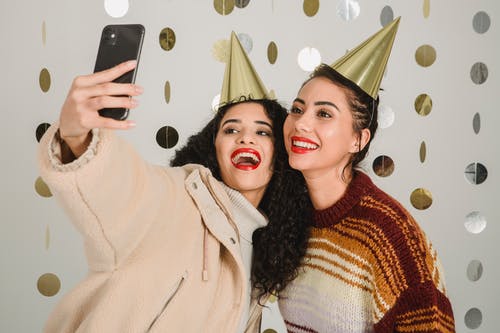 Instagram-onderschrift bij selfie van twee vriendinnen met gouden kegelhoeden 