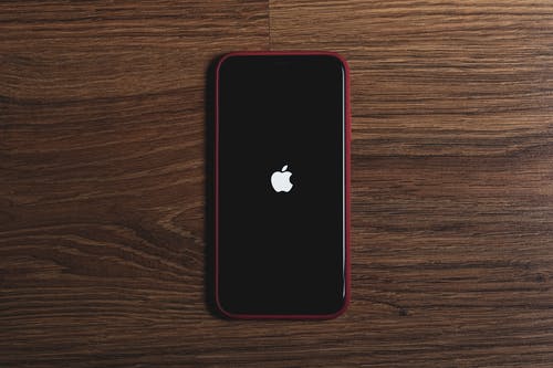 Teléfono negro con el icono de la manzana en una pantalla negra