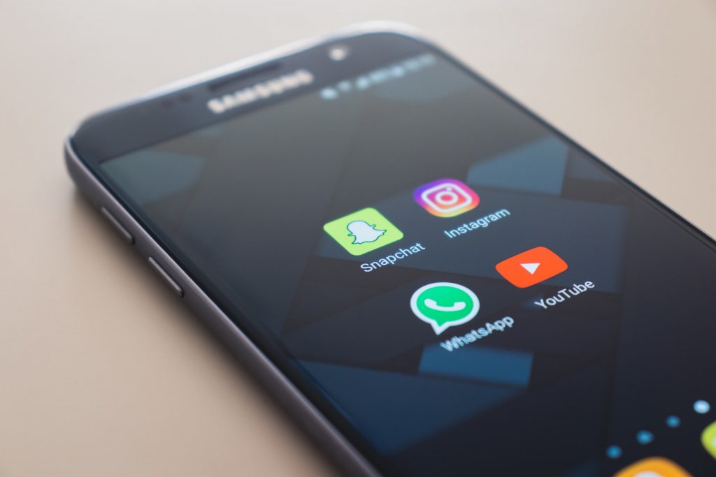 Android phone with Instagram app, Snapchat, WhatsApp and Youtube app icons on the screen.