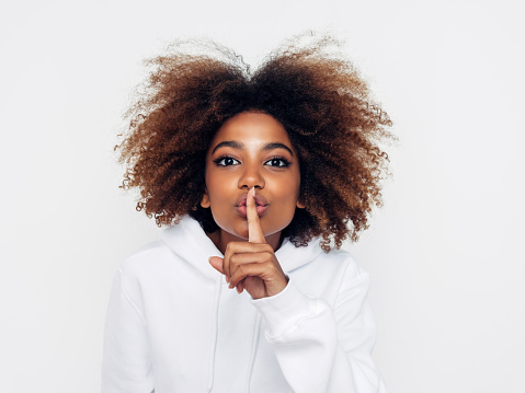 Beautiful afro woman showing to be quiet | Path Social Femme faisant le geste du chuchotement pour représenter le mode Vanish sur Instagram