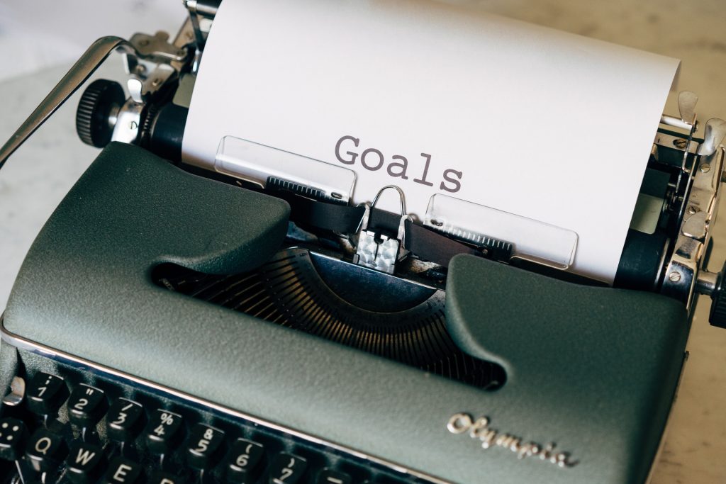 Define Goals for Your Instagram Growth | Path Social uma máquina de escrever com uma folha de papel dentro