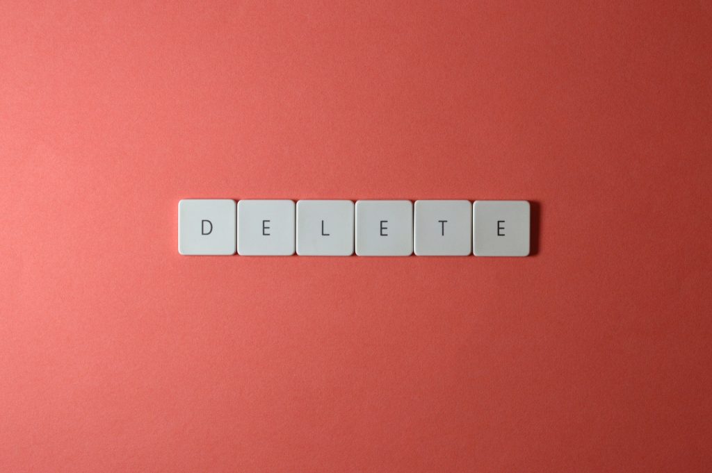 Suppression de l'orthographe sur des cubes de lettres sur fond rouge.