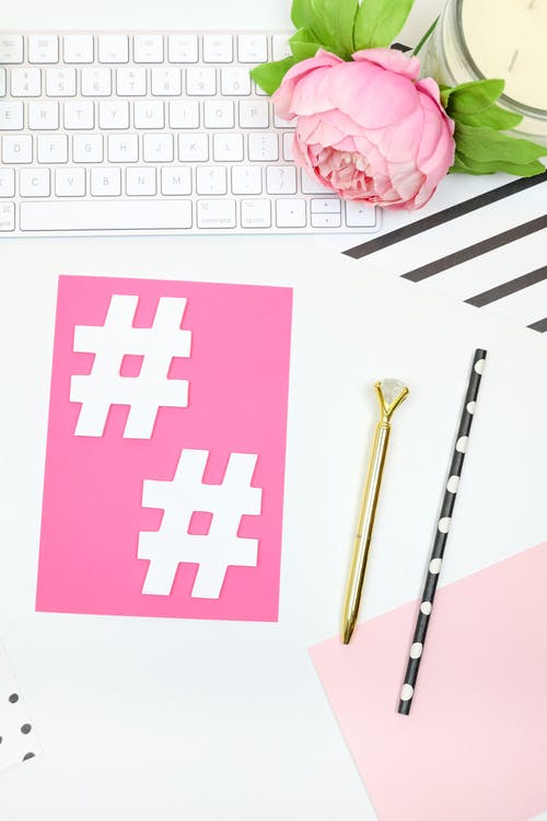 Weiße Hashtag-Symbole auf rosa Papier. 