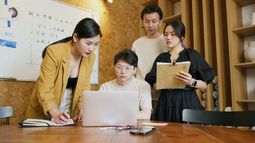A group of people around a laptop working on their Instagram advertising strategy to get more followers on Instagram.