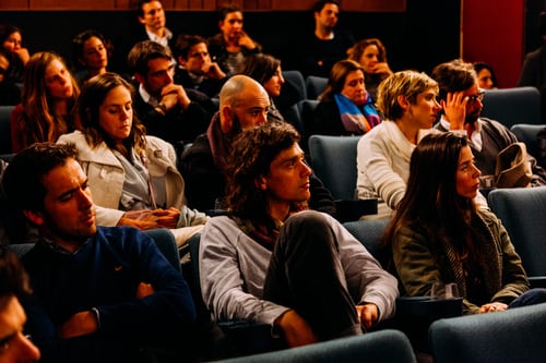 Uma sala cheia com uma audiência atenta para mostrar uma estratégia eficaz de segmentação de audiências para Instagram.