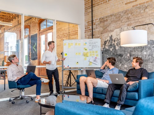 Quatre hommes devant un tableau blanc discutent de leur stratégie d'affichage sur le site Instagram .