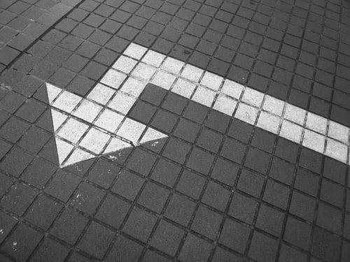 A white arrow painted on a sidewalk to represent defined goals for Instagram growth.