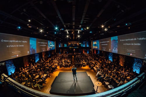 A large audience and a speaker in an auditorium to represent effective audience targeting with interesting Instagram content