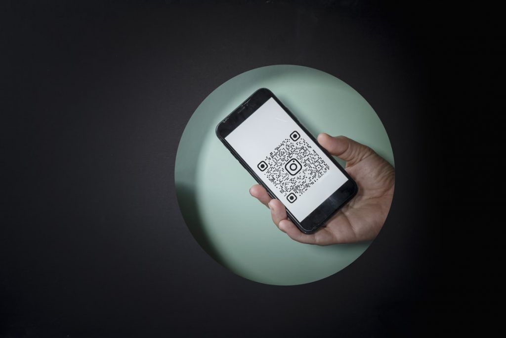 Phone displaying QR code to represent Instagram QR code for brands.