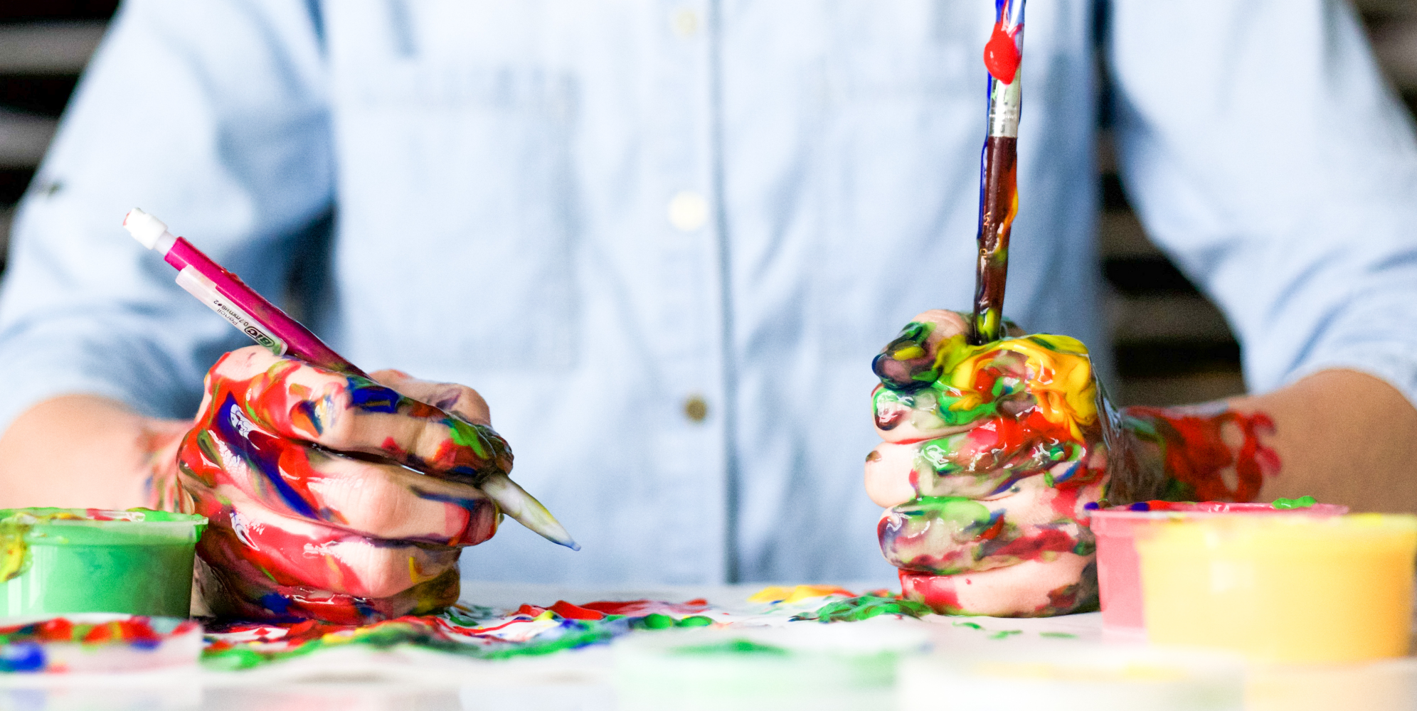 art1 | Path Social A person painting to grow their art on Instagram, with hands covered in different colors of paint.