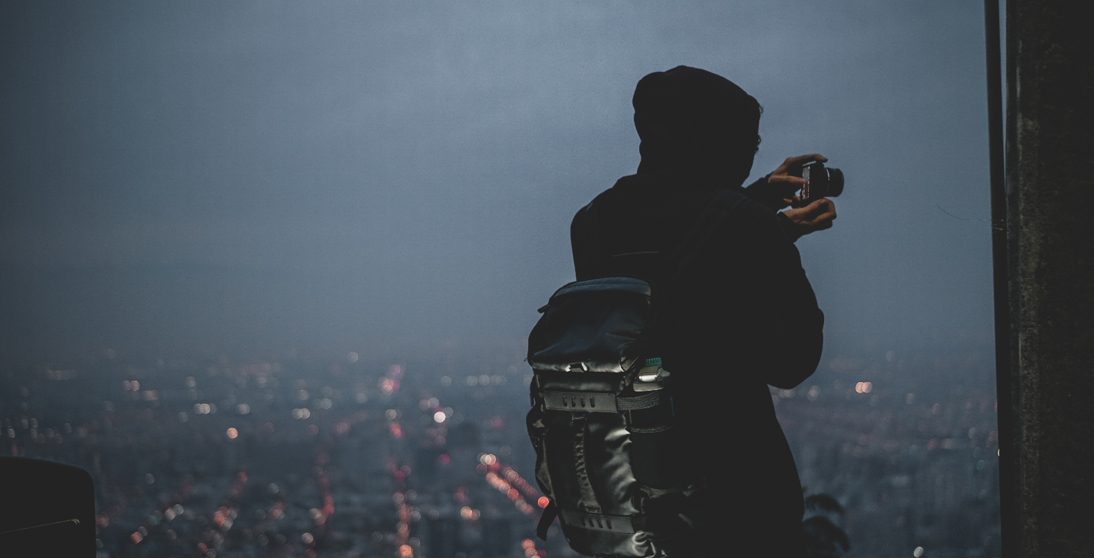 Person taking a nighttime cityscape photo for Instagram.