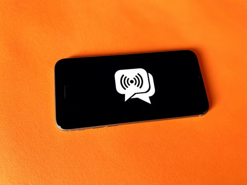 A black phone displaying two, overlapping Instagram message chat icons on the screen.