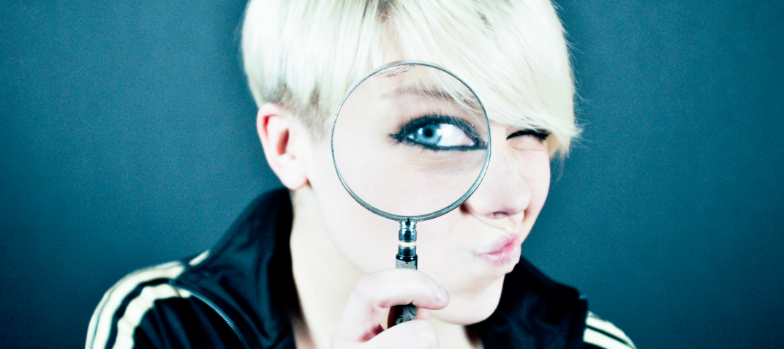 Woman looking through a magnifying glass demonstrating how to check Instagram growth.