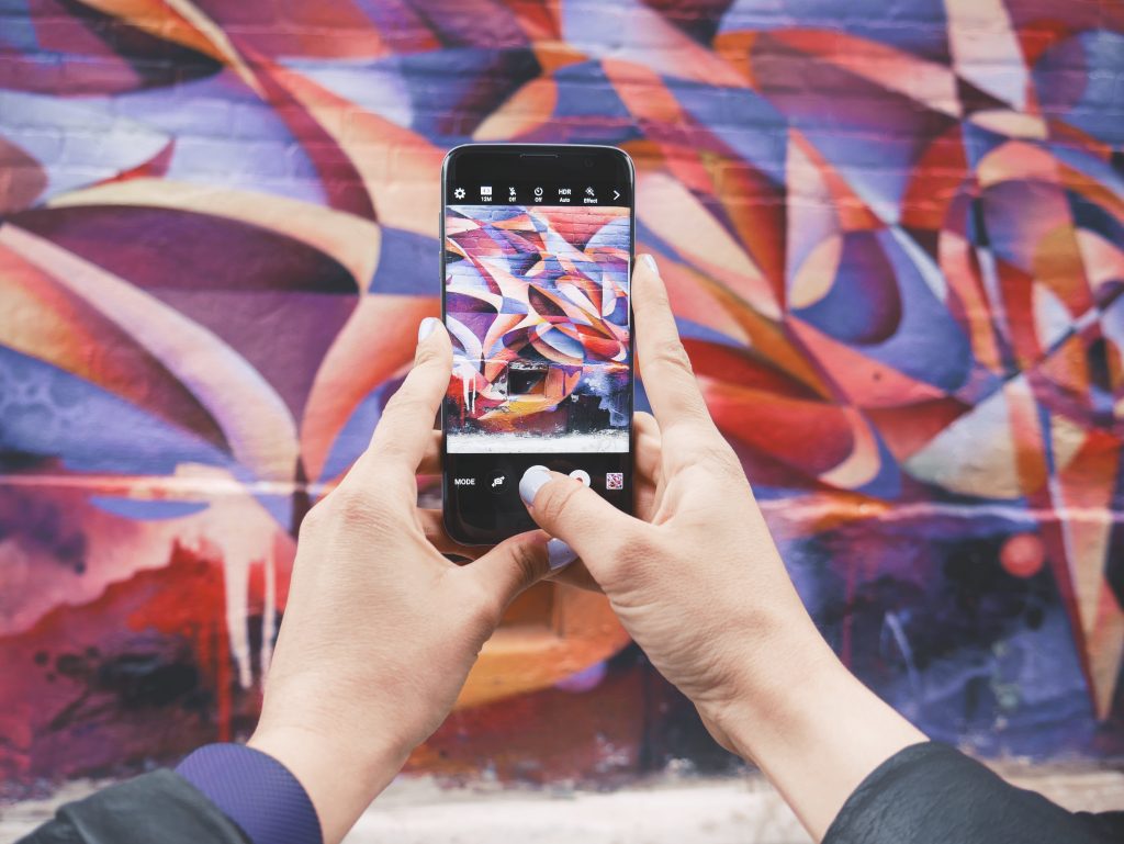 una persona que sostiene un teléfono y está haciendo una foto