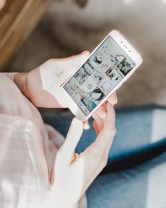 woman holding phone showing Instagram Explore page