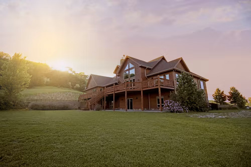 Brown wooden house in the middle of a big green lawn advertising prime real estate on Instagram.
