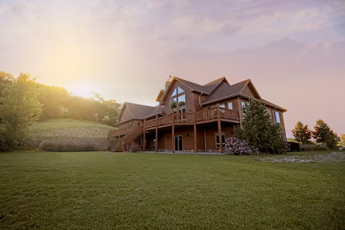 Casa de madeira castanha no meio de um grande relvado verde a anunciar um imóvel de primeira qualidade em Instagram. 