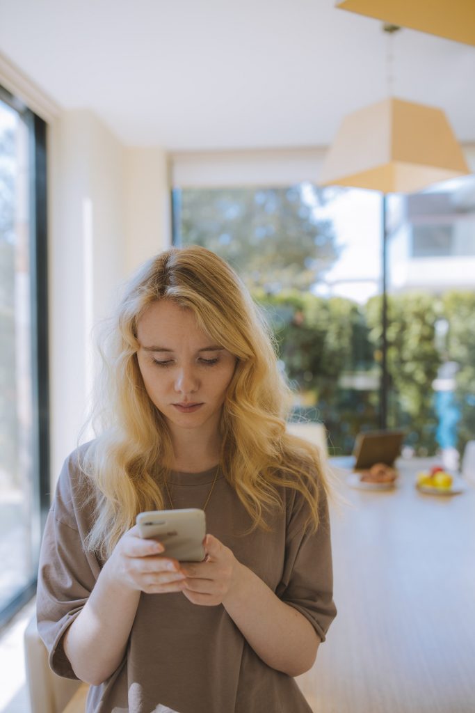 Women holding a smartphone and learning how to make a reel on Instagram.