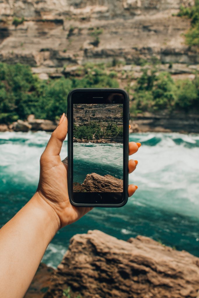 Person holding smartphone to record video of view.