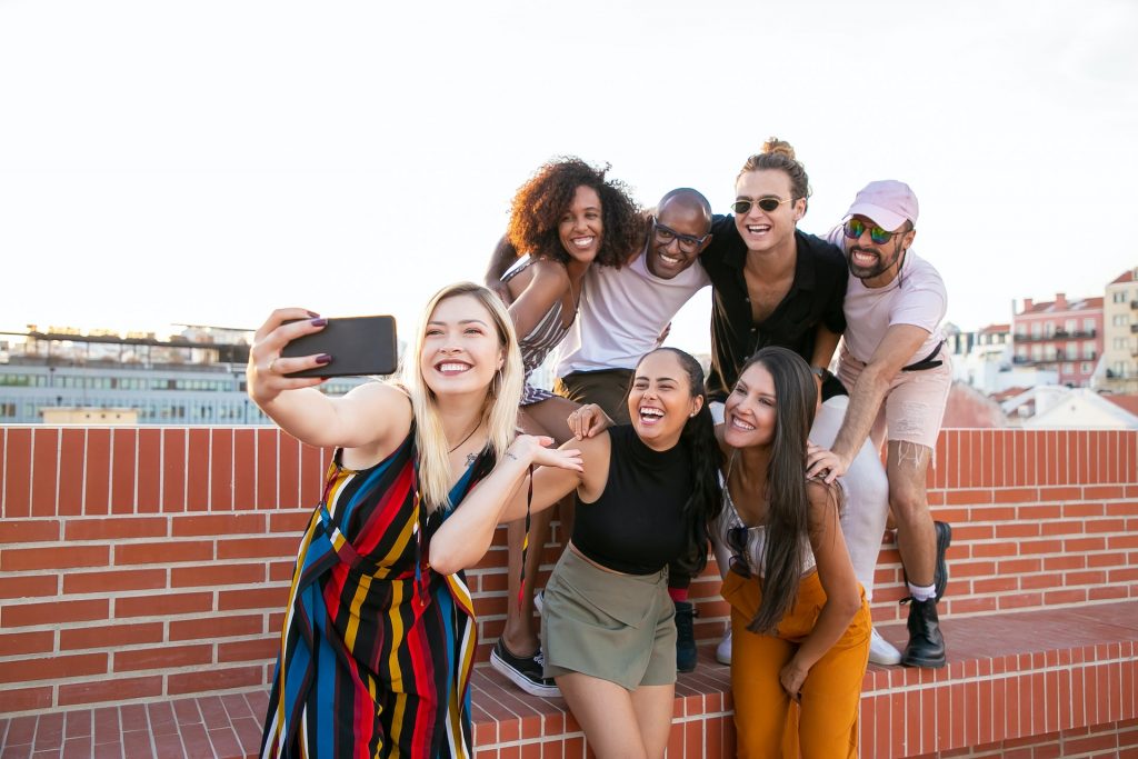 Group of people taking a selfie on a city rooftop.