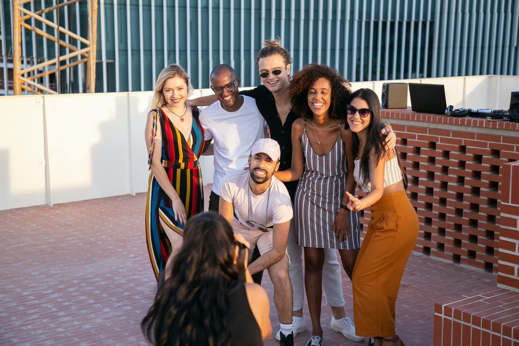 Group of friends on a rooftop getting their picture taken.