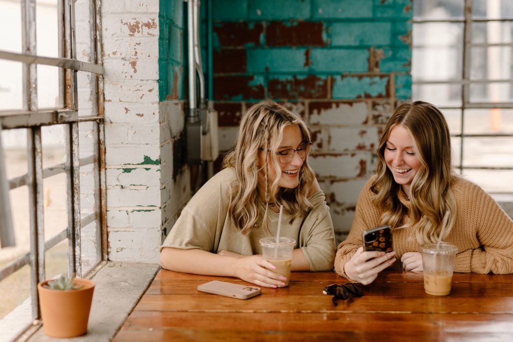 Two girls watching something on smartpfone.
