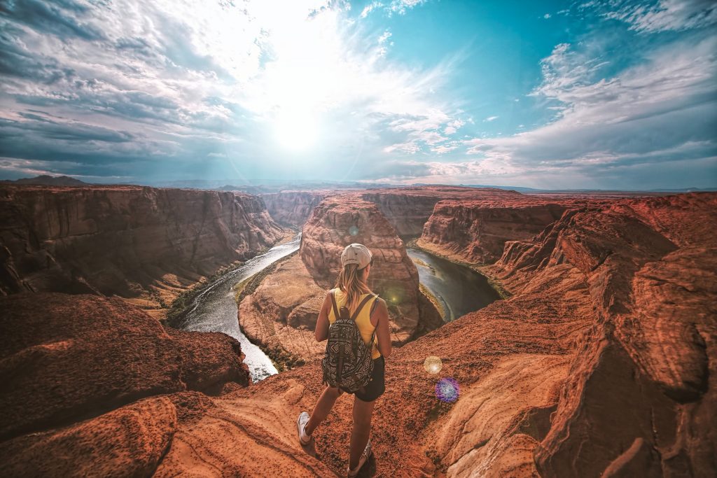 Femme se tenant au sommet d'un canyon pour poster et taguer sur Instagram. 