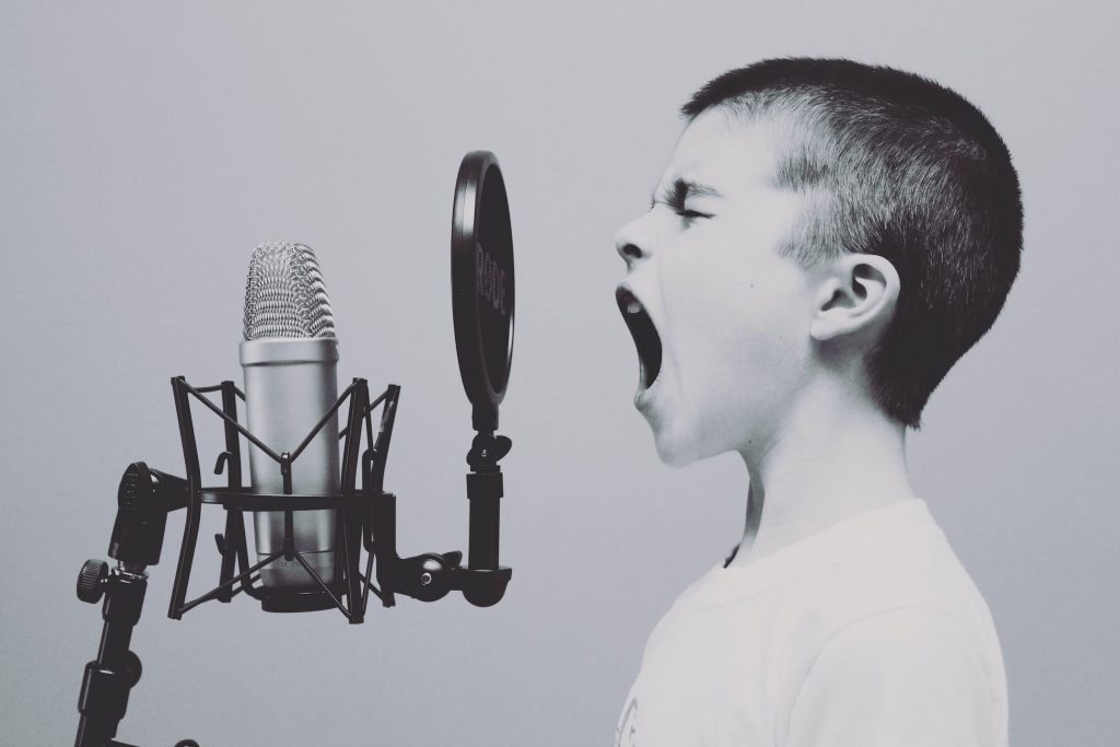 A boy shouting into a microphone to represent active discussions about a brand on Instagram and other social media platforms. 