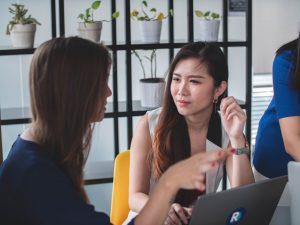 Two women discussing how social listening can help them get more Instagram followers.