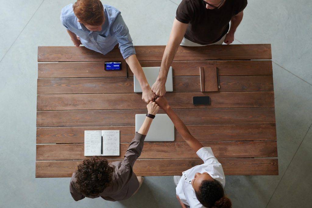 un grupo de personas cogidas de la mano alrededor de una mesa