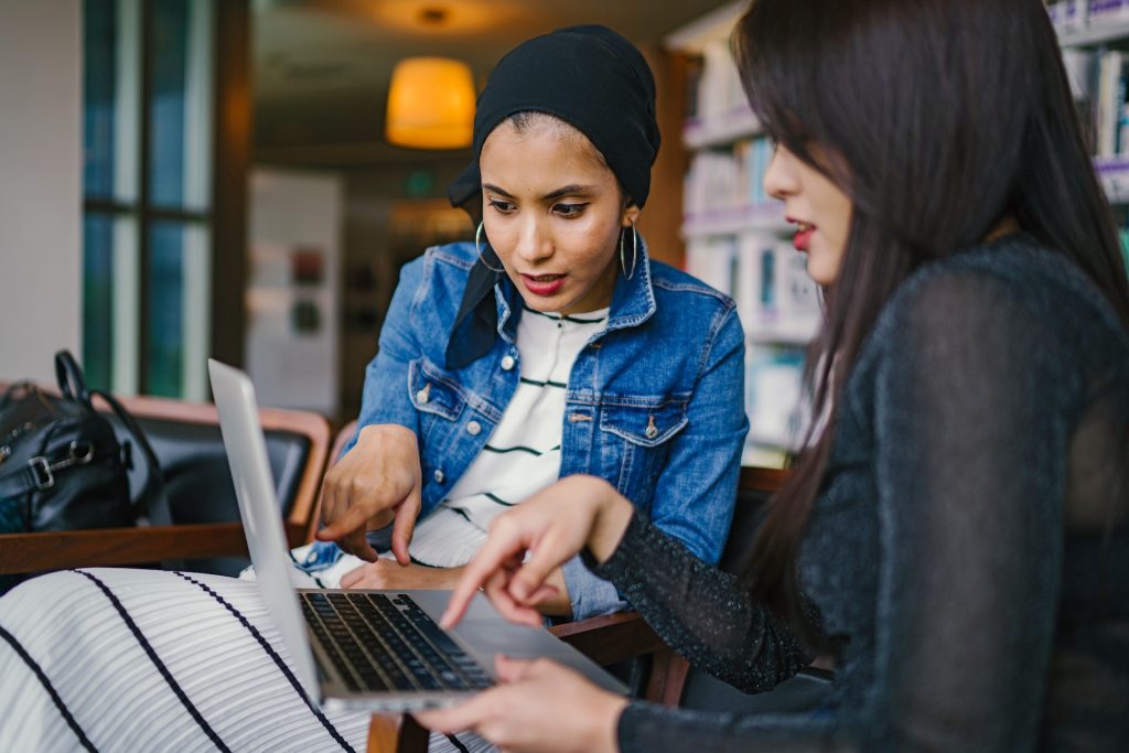 Dos mujeres utilizando un ordenador portátil.