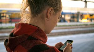 Person looking at smartphone, watching content from her favorite macro influencers on Instagram.