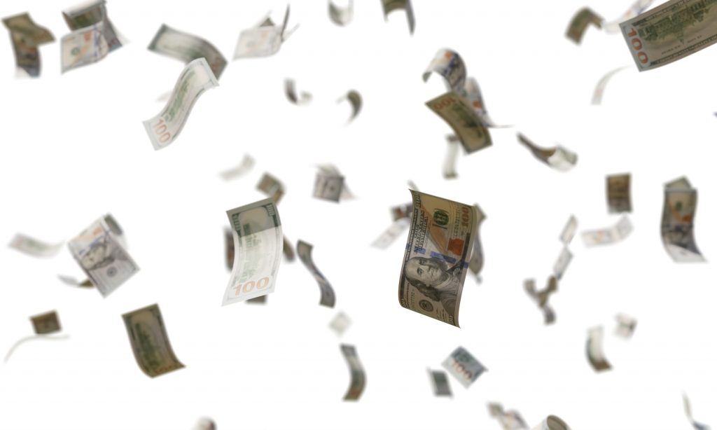 Billete de 100 dólares estadounidenses flotando en el aire sobre un fondo blanco.