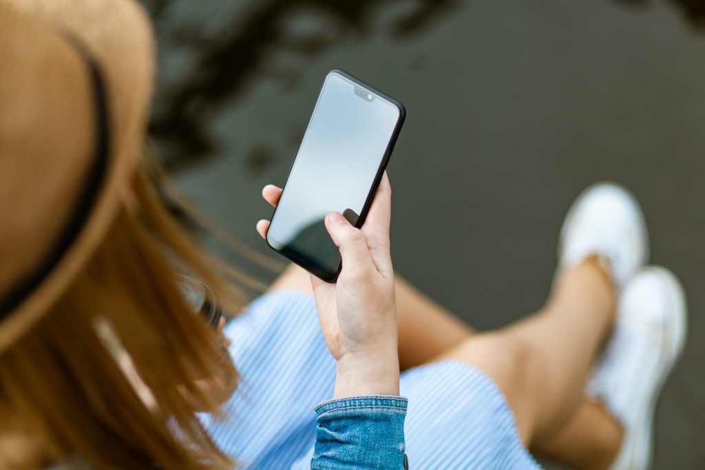 A person holding smartphone while sitting.