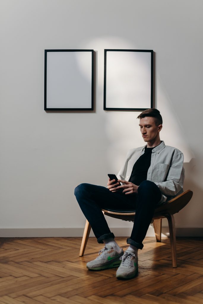 Man working on his phone, wondering how to gain Instagram followers organically.
