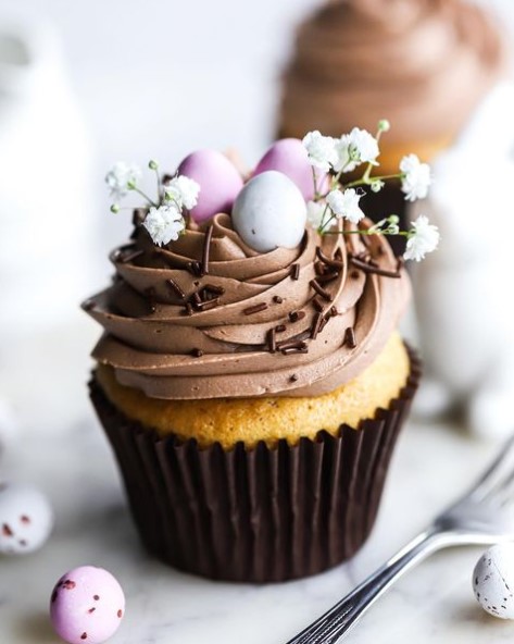 Een cupcake met paasthema en kleine paaseitjes bovenop.