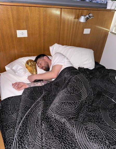 Foto de Instagram del futbolista Leo Messi durmiendo con el trofeo de la Copa Mundial de la FIFA.