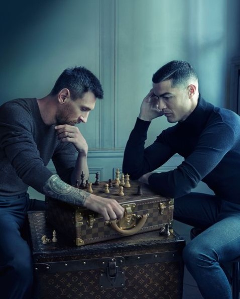 Two men playing chess on top of luggage trunks.