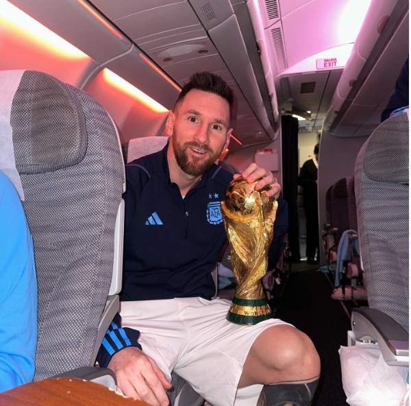 Superestrella del fútbol con trofeo en un avión.