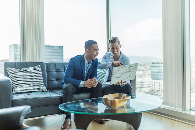 Two men on a sofa watching an Instagram video showing how to tag products in Stories.