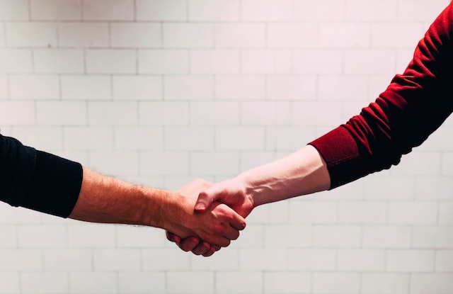 Two people shaking hands symbolizing brand partnership.