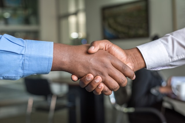 Duas pessoas apertam as mãos para selar uma colaboração de marca.