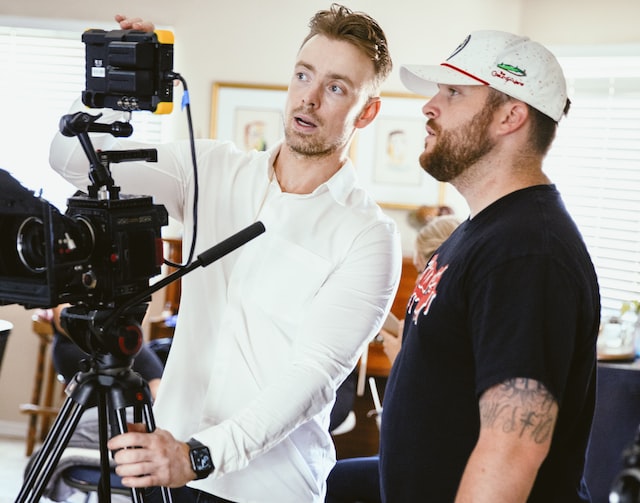 Foto van een groep mannen op de set die een scène bespreken om te laten zien wat er achter de schermen gebeurt voor een Instagram post. 