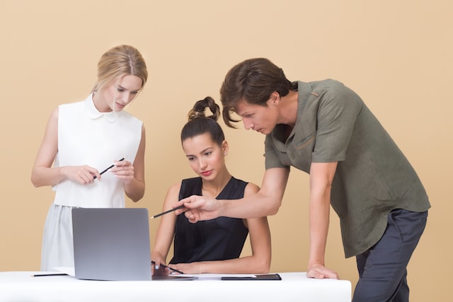 Three young professionals discussing Instagram management strategies.
