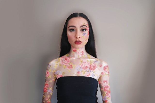 Donna Instagram influencer con body paint floreale.