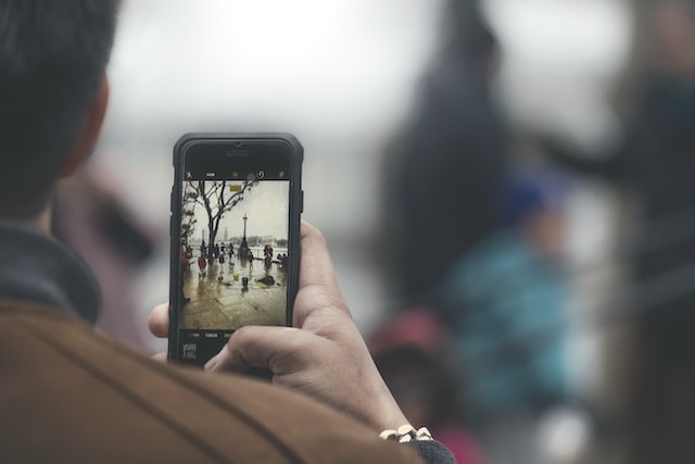 Person, die mit einem Smartphone ein Video für eine Instagram Rolle aufnimmt.