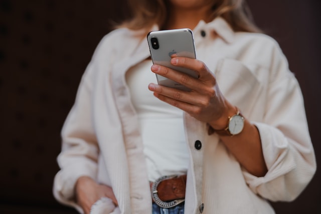 Une femme qui regarde son smartphone en se demandant comment marquer les messages Instagram comme non lus.