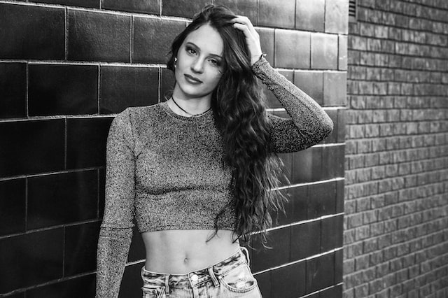 Black and white photo of an Instagram model in front of a brick wall