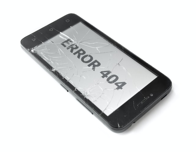 Primo piano di uno smartphone danneggiato con &quot;Error 404&quot; sullo schermo.