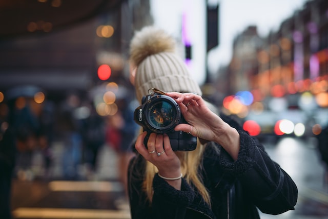 Persoană care face o fotografie cu un aparat foto profesional.